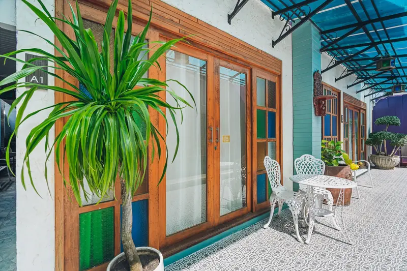 Plants, handpicked furniture and colourful wooden doors beside the courtyard