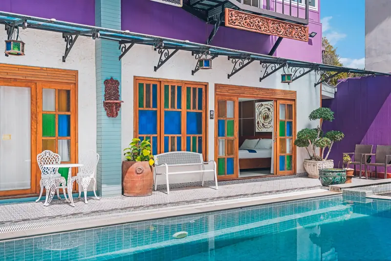 Poolside seating outside the colourful rooms at The Villager
